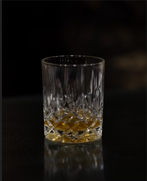 cup of alcoholic drink against black backdrop