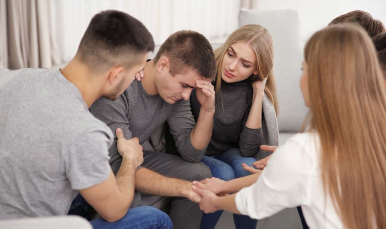 Male surrounded by a Supportive Group of People