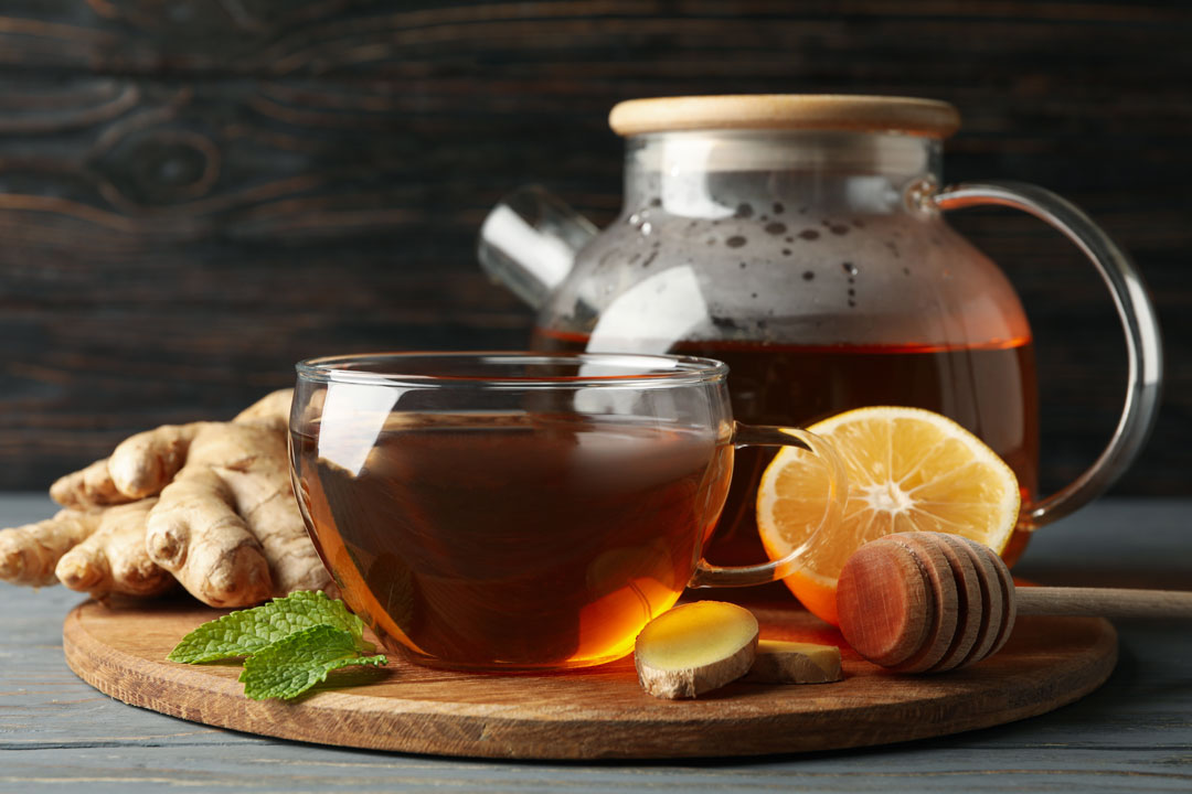 pitcher of herbal tea on wooden background