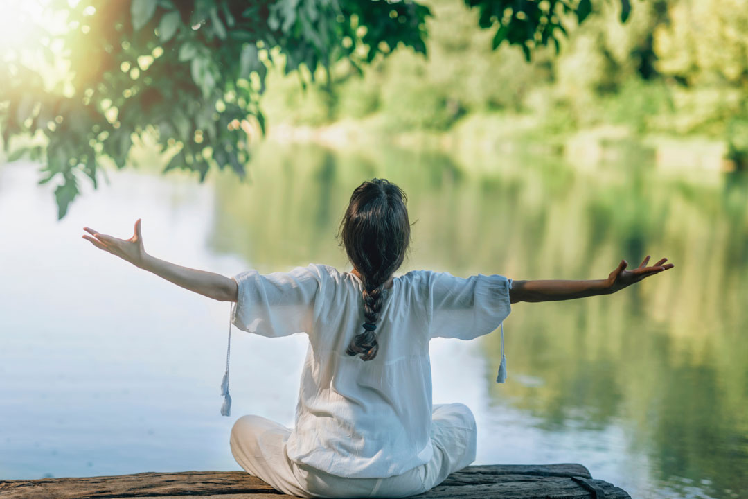 woman doing yoga by the lake