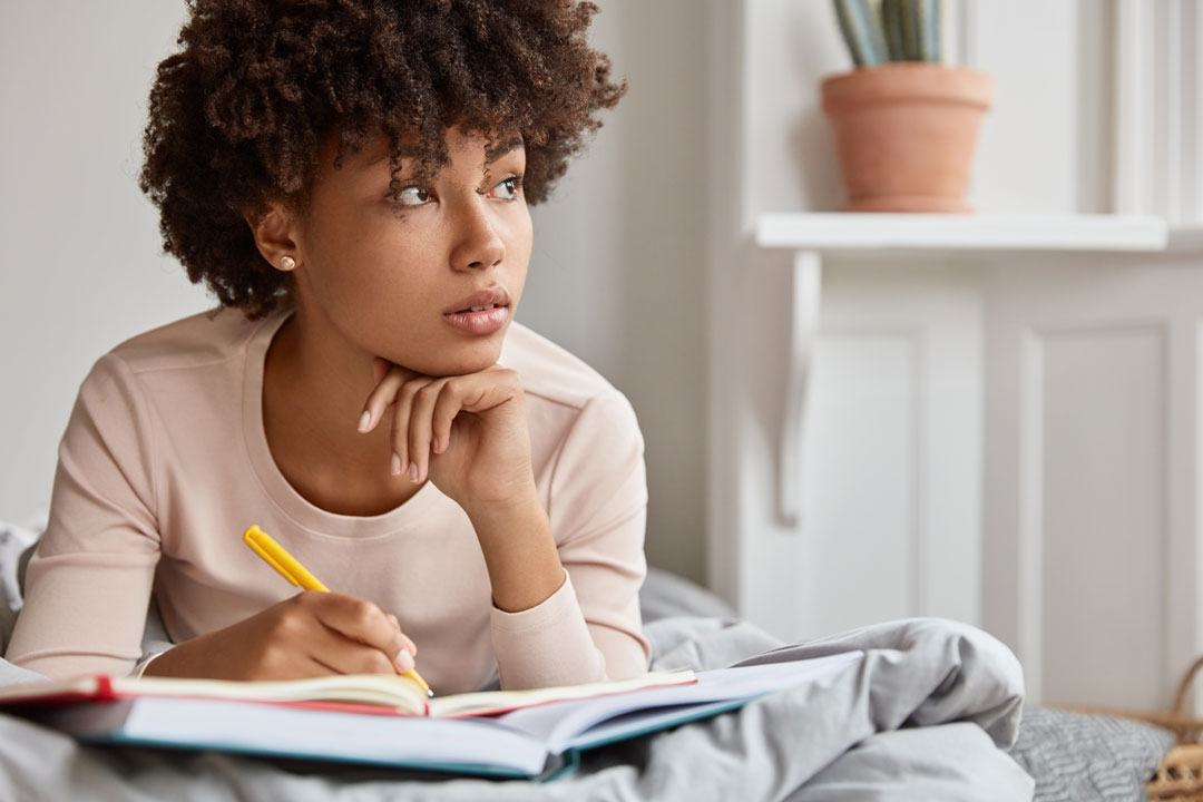 woman journaling looking thoughtful