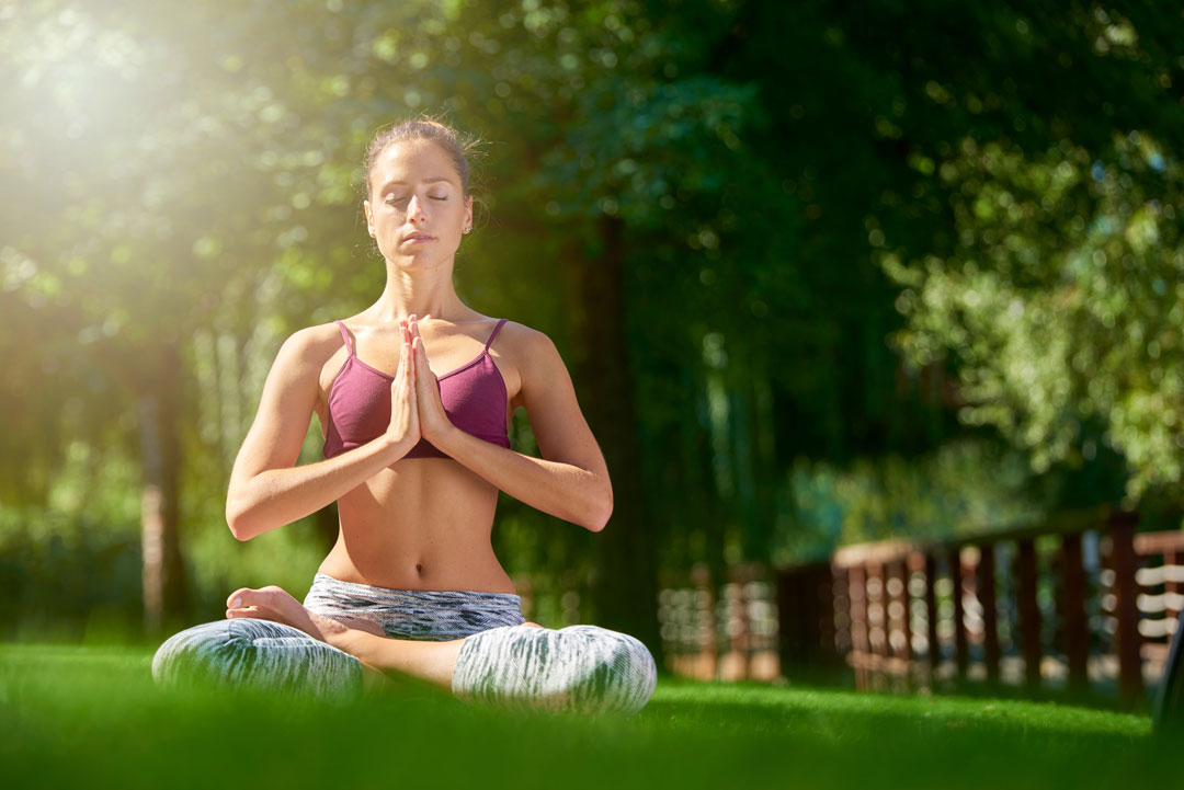 woman practicing yoga in the park