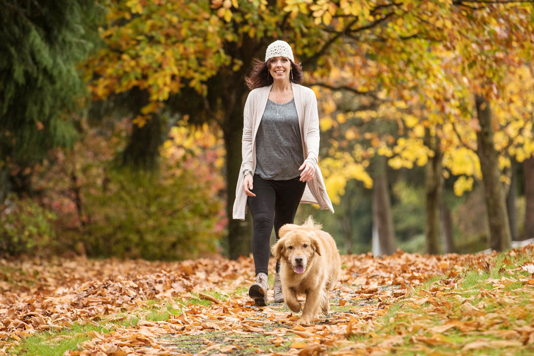 woman walking dog in fall